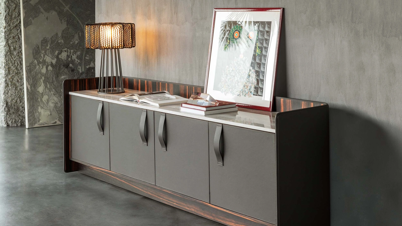 Madia Gentleman con struttura in legno multistrato curvato rivestito esternamente in pelle grigia, internamente in ebano con top in marmo di Flou