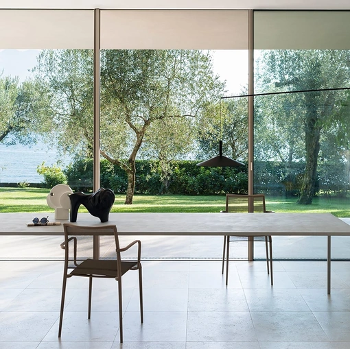 Tavolo 25 elegante e compatto, con top finitura in cemento di Desalto